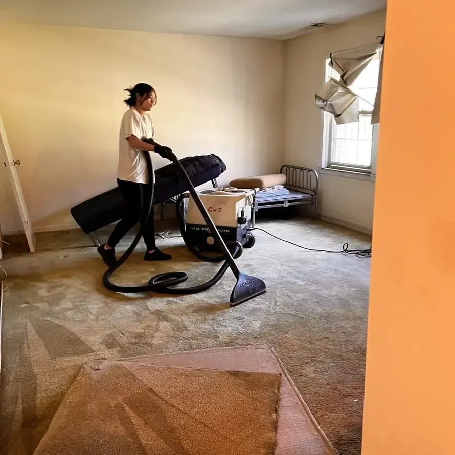 Extraction wand pulling water out of a soaked bedroom carpet